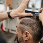 Мъж масажира скалпа си като част от ежедневна грижа за здрава коса